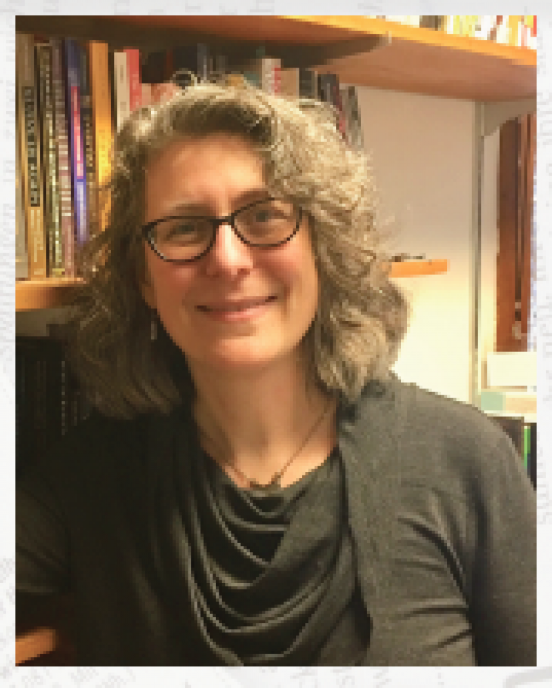 Color Photograph of Dr. Erica Andrus in front of a library book shelf