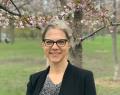 Color headshot image of Dr. Pamela Klassen standing outside in front of blossoming trees with green grass in the background