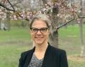 Color headshot image of Dr. Pamela Klassen standing outside in front of blossoming trees with green grass in the background