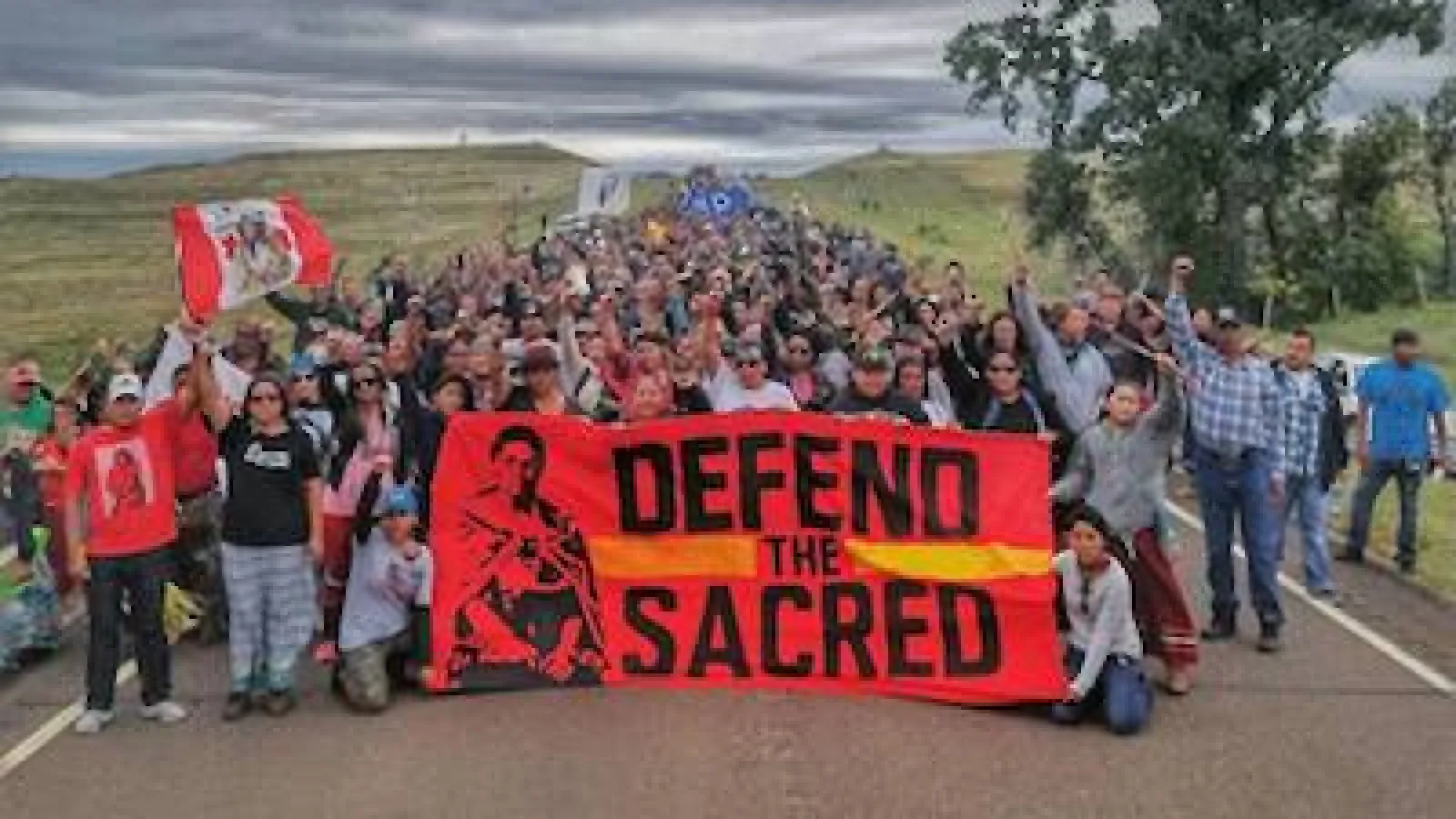 Crowd holding "Defend the Sacred" banner