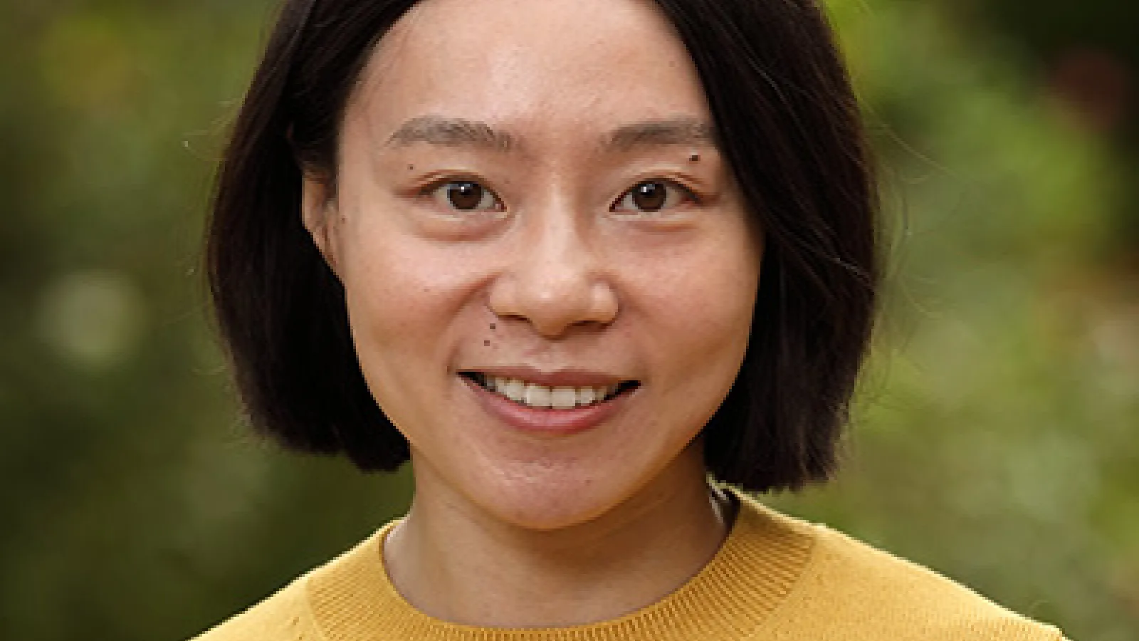 Headshot of J Liang, an Asian woman with a bob haircut and yellow sweater. 