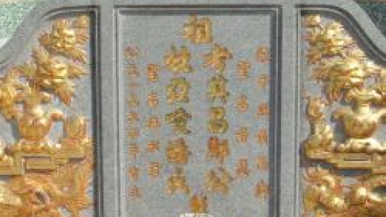 Door with Chinese writing on it and gold dragons to either side