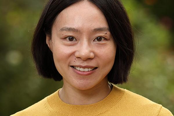 Headshot of J Liang, an Asian woman with a bob haircut and yellow sweater. 