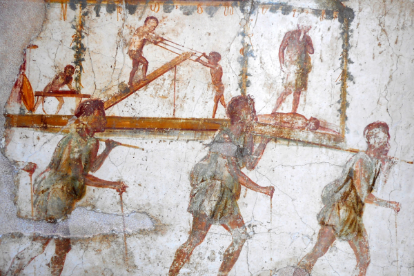 Cave painting of 3 men carrying a log with more workers in the background.