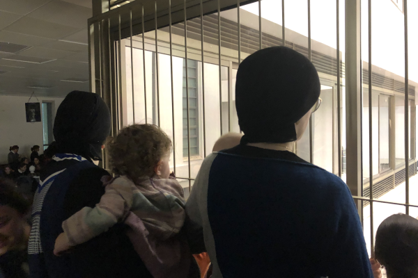 the backs of women's heads as they look out a window