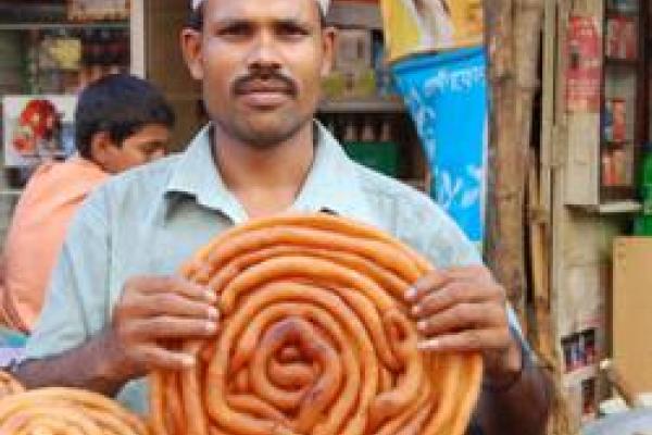 A person holding a breaded pastry