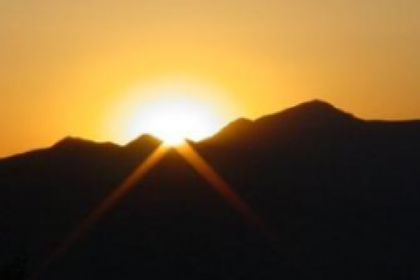 A sun setting over a mountain range